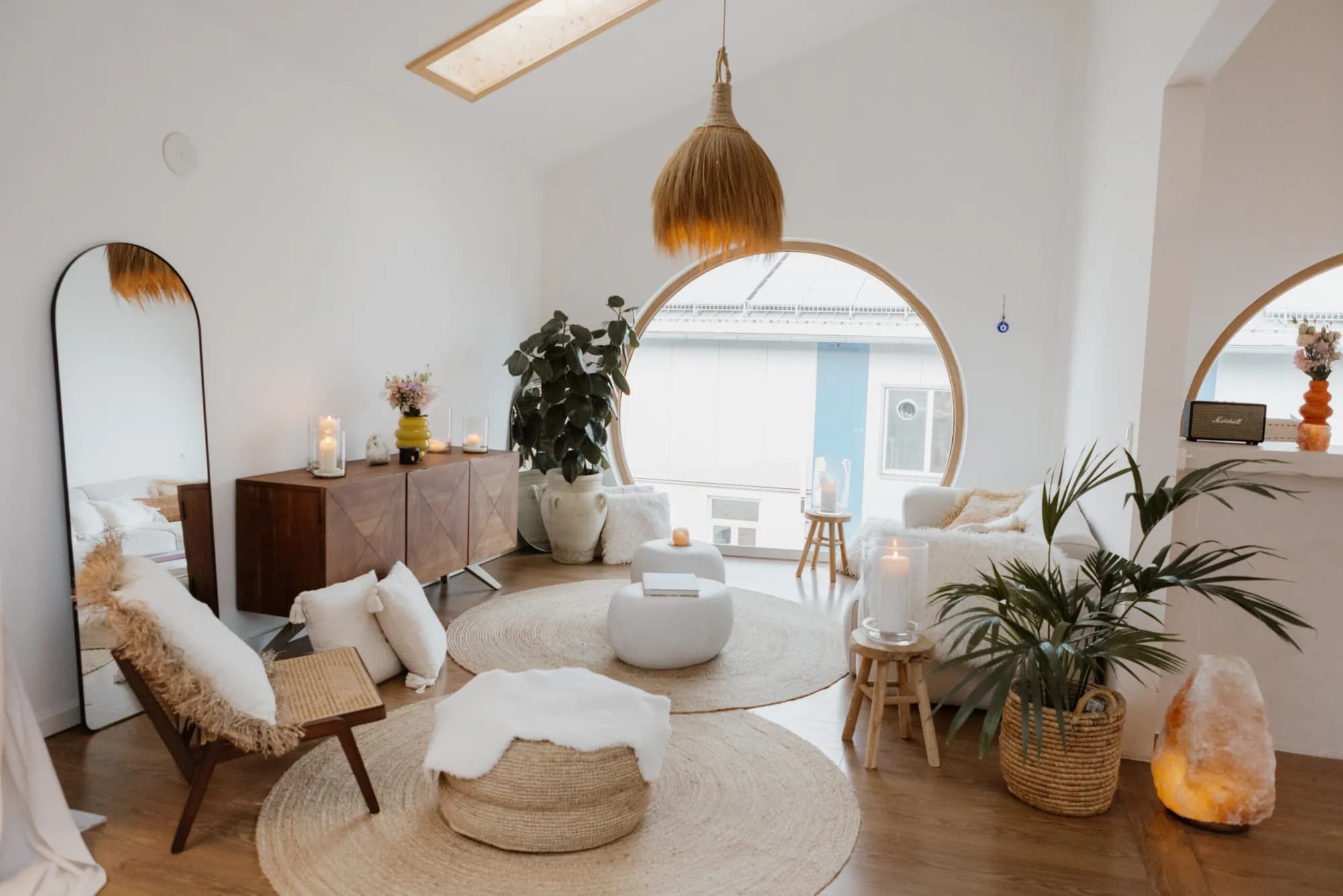 Helle Lounge-Ecke mit Rundfenster, Pflanzen und Sitzkissen